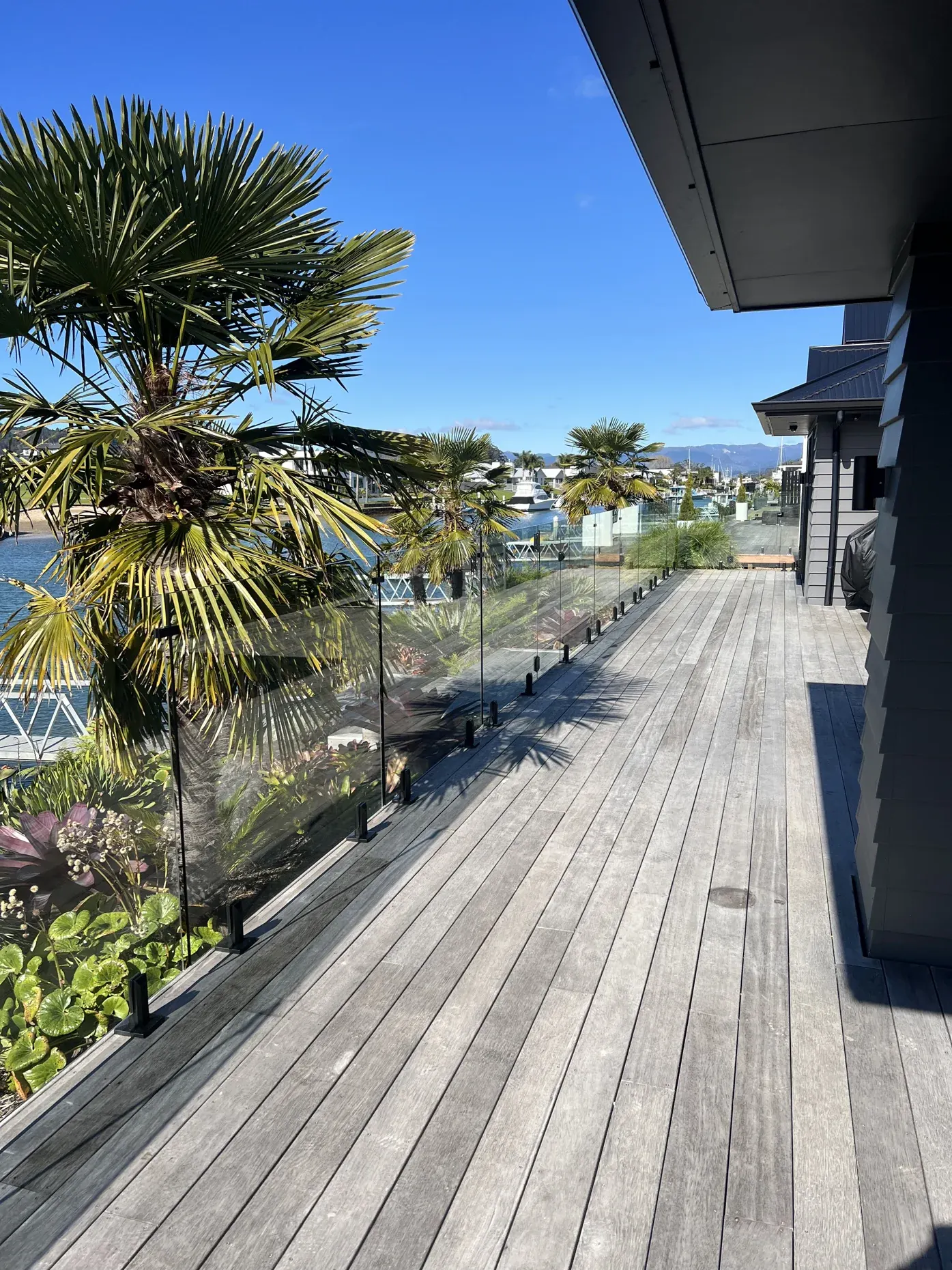 Whitianga: frameless glass balustrade along a canal-side deck, by TK Glass NZ